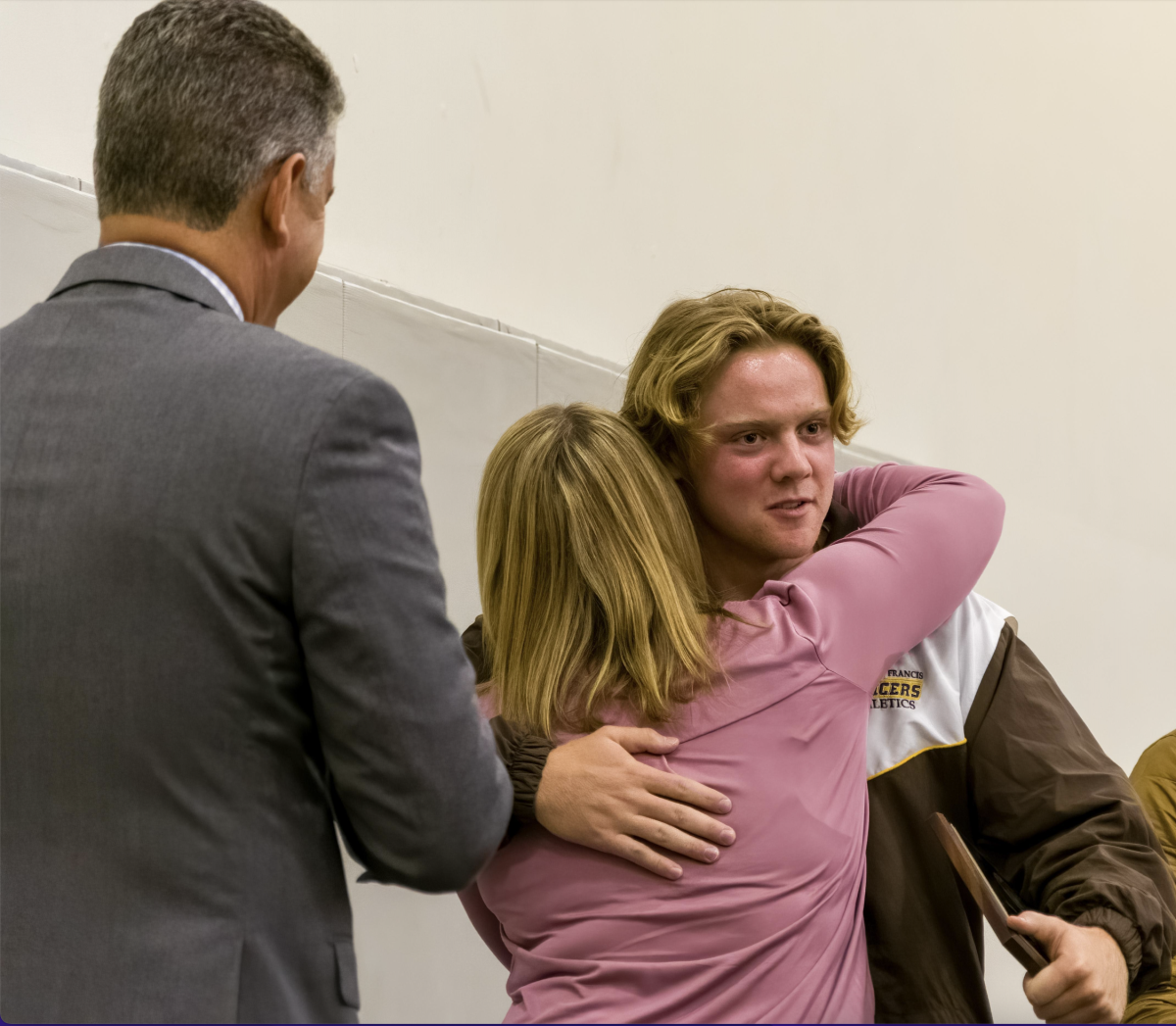 President Jason Curtis (left) and Principal Katie Teekell ('00) congratulate Andrew Adkison ('23) with the Holy Cross Award.