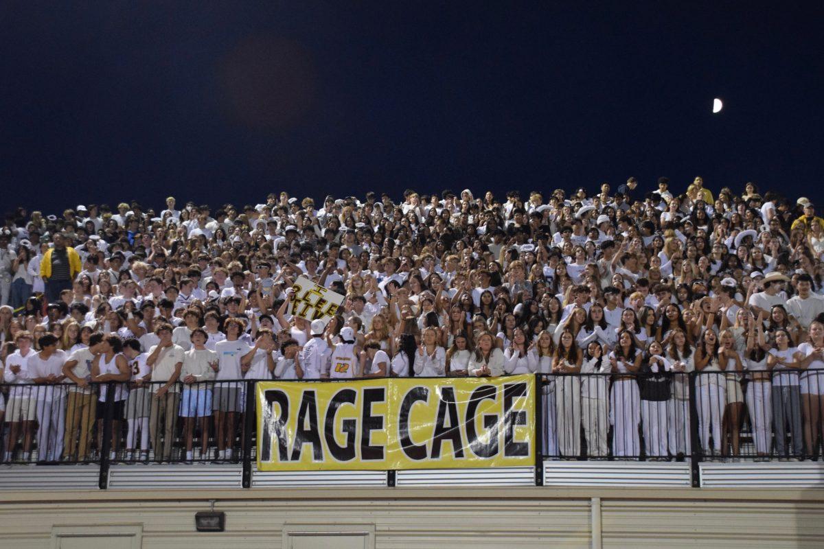 In the first quarter of the game, the students in the Rage Cage eagerly watch the players, holding up their “I Believe” poster.