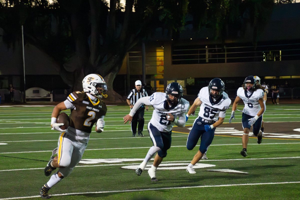 Kingston Keanaaina ('25) runs the ball down the field.