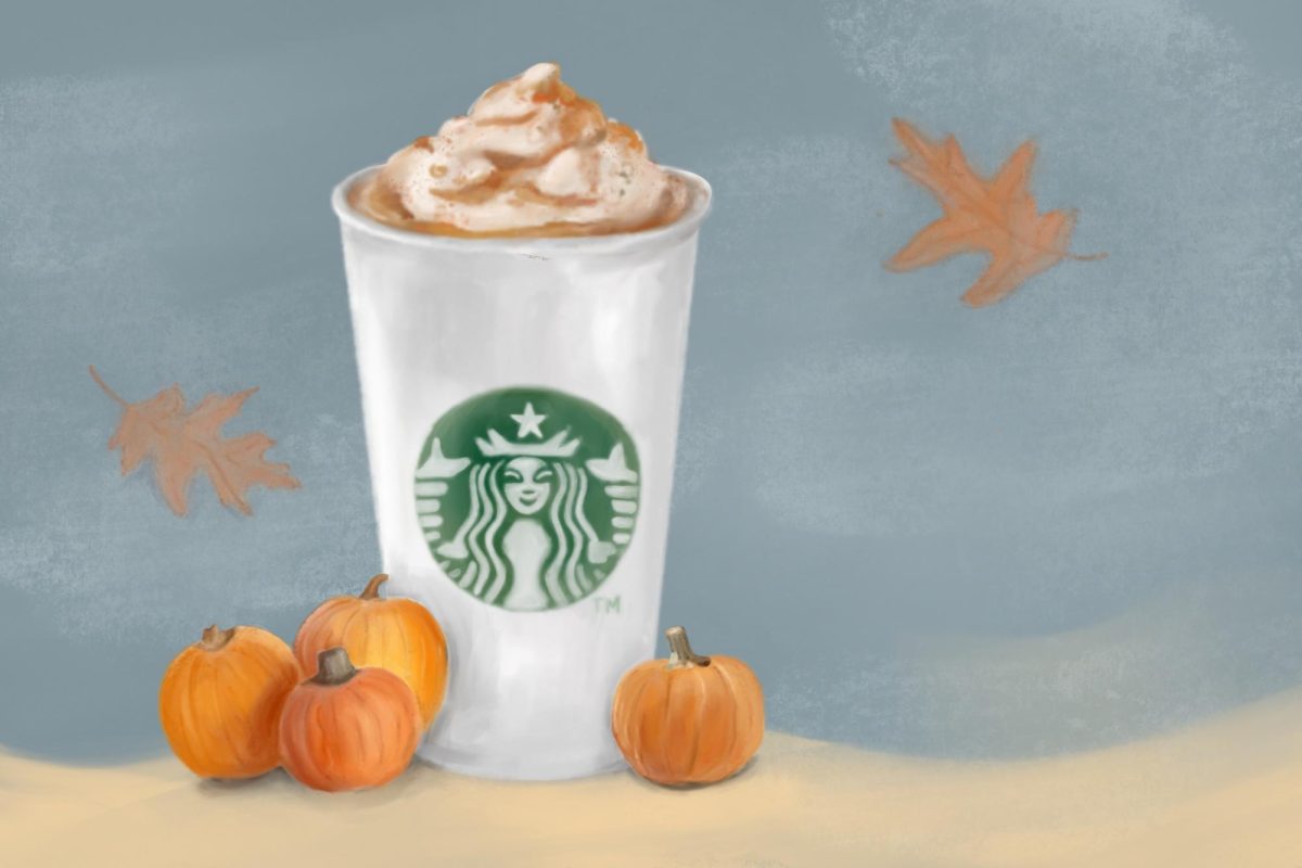 A Starbucks Pumpkin Spice Latte sits nestled between pumpkins while autumn leaves fall behind.