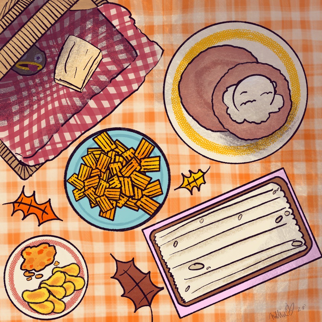 A spread of fall foods on a picnic blanket.