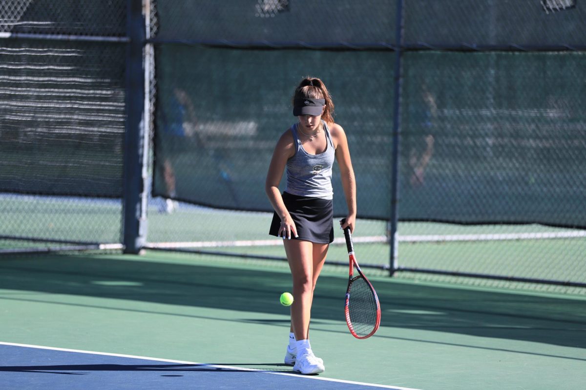 Sloane Swenson (’27) bounces the ball before serving it to the opposing player.