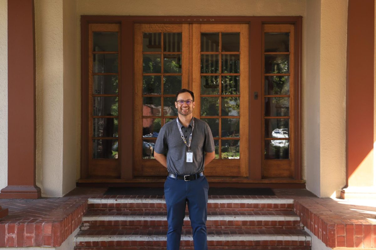 Mr. Zachary Herhold poses in front of Andre House.