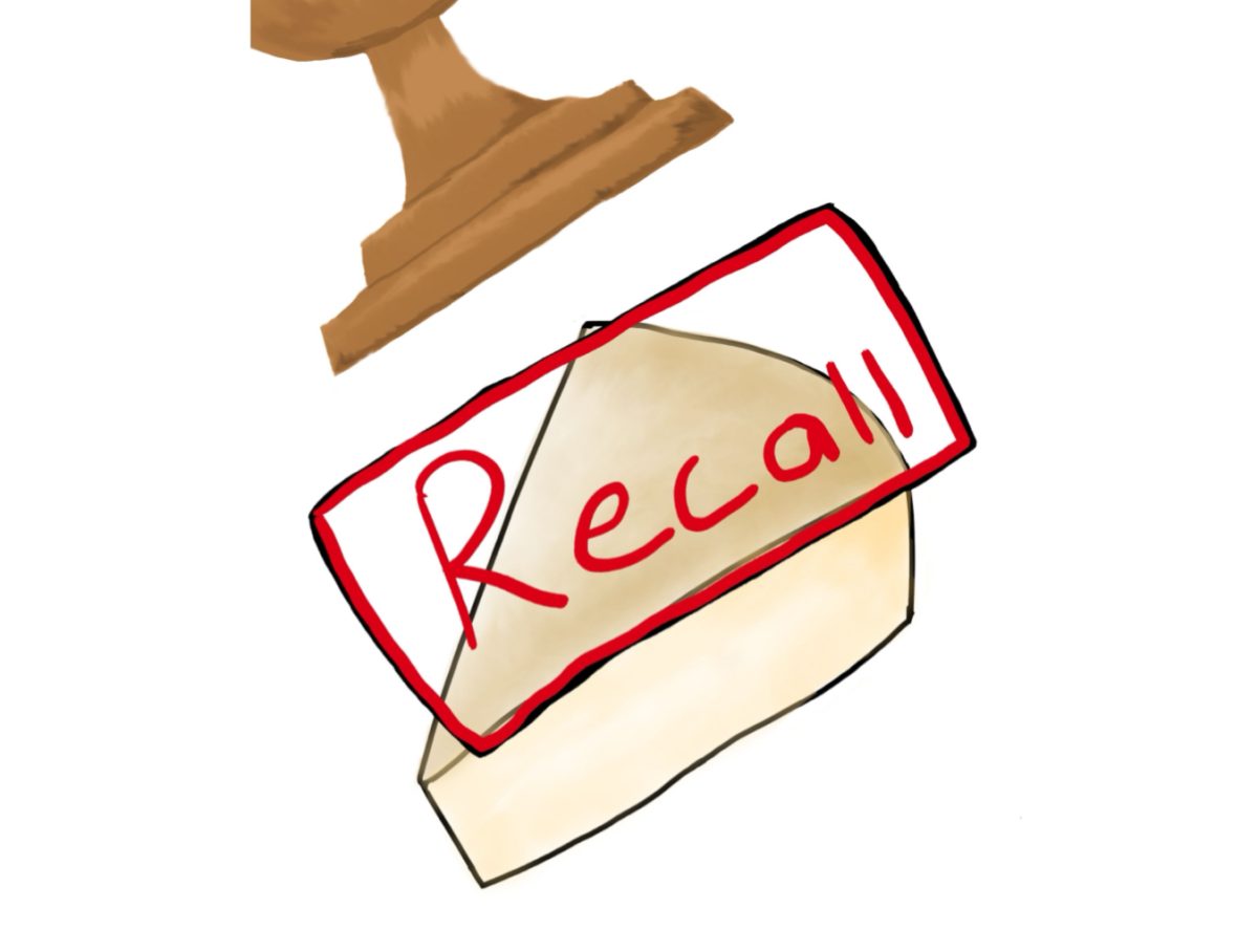 A wedge of cheese being stamped with "Recall" label.