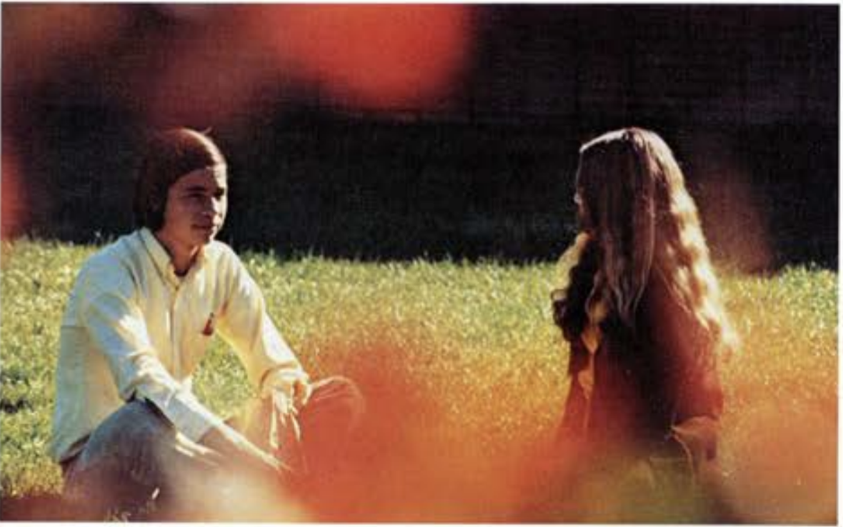 A boy and girl hang out in the Quad.